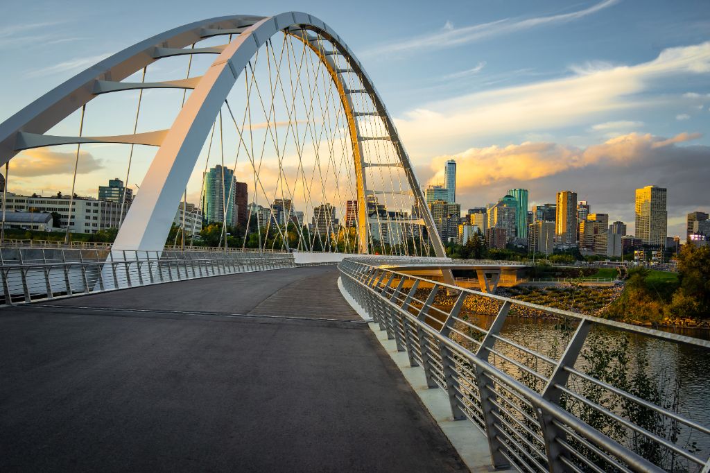 Edmonton, Alberta, Kanada Skyline in der Abenddämmerung mit Hängebrücke im Vordergrund und Wolken