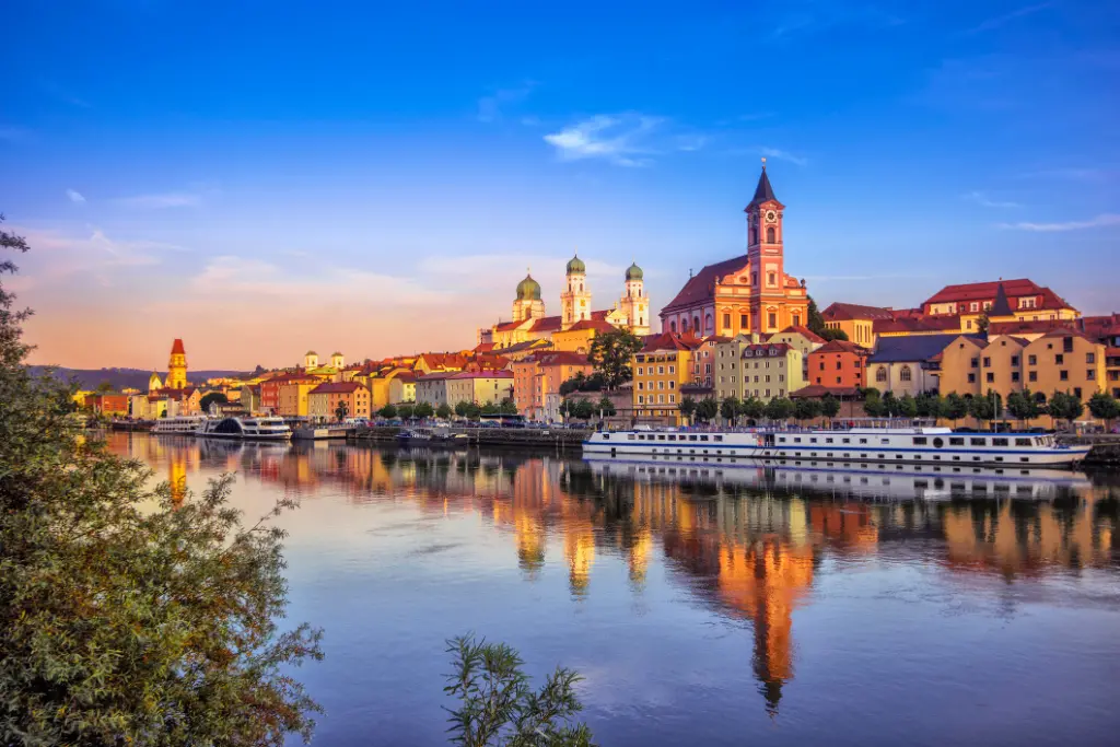 Die Uferpromenade und die Ausflugsschiffe in Passau bei Sonnenuntergang.