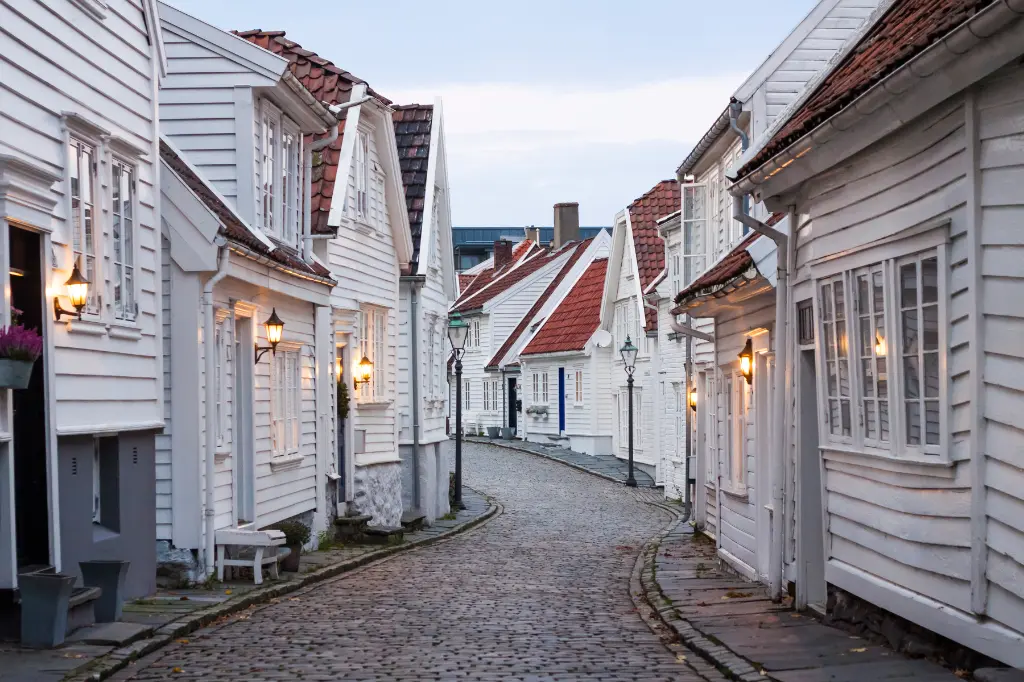 Traditionelle skandinavische Kopfsteinpflasterstraße mit weißen Häusern in Stavanger, Norwegen