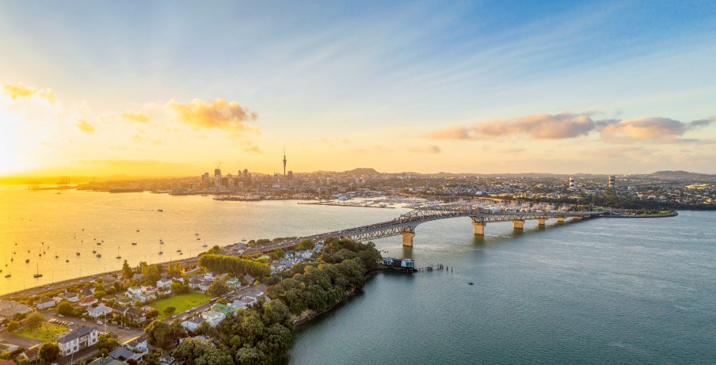 Ein Panoramabild von Auckland von oben, mit dem Sky Tower und dem Stadtzentrum über dem Waitemata Harbor und der Auckland Harbour Bridge.