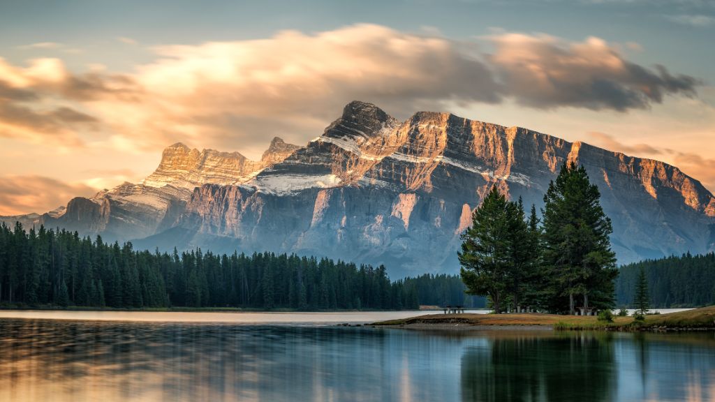 Früher Herbstmorgen am Seeufer.  Wunderschöne Sonne und Wolken über dem Mount Rundle