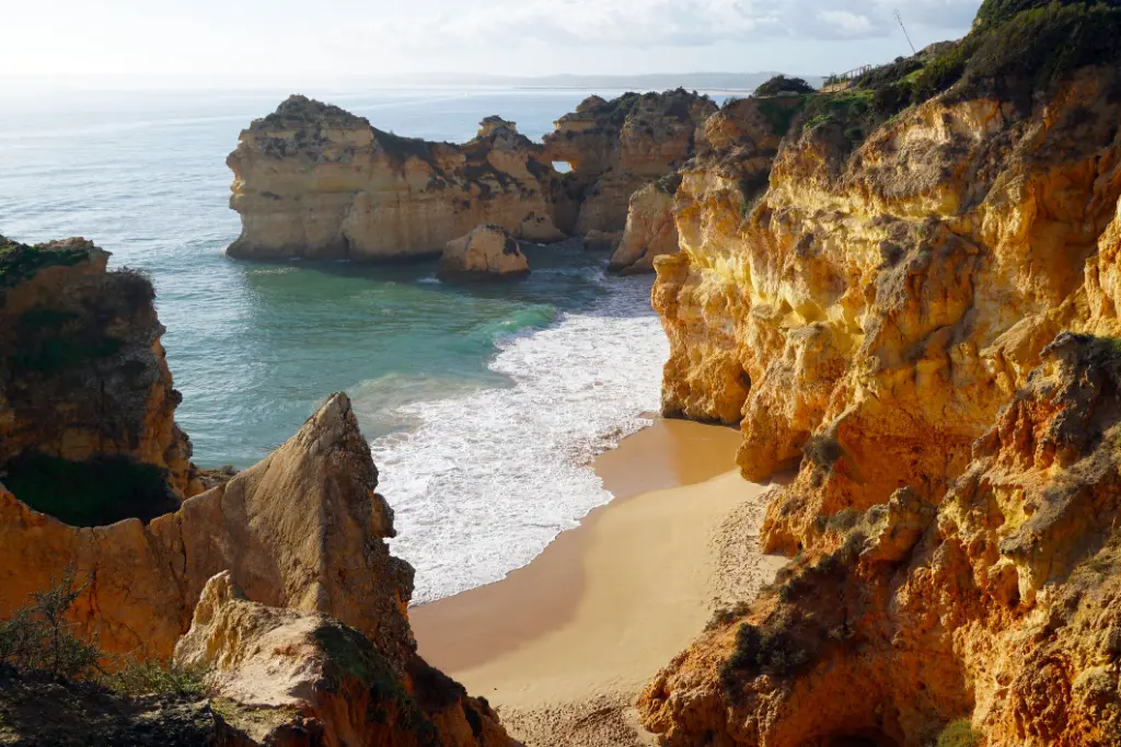 Marinha Beach sehr beliebter Strand mit typischen Felsformationen als natürliche Brücken und Bögen